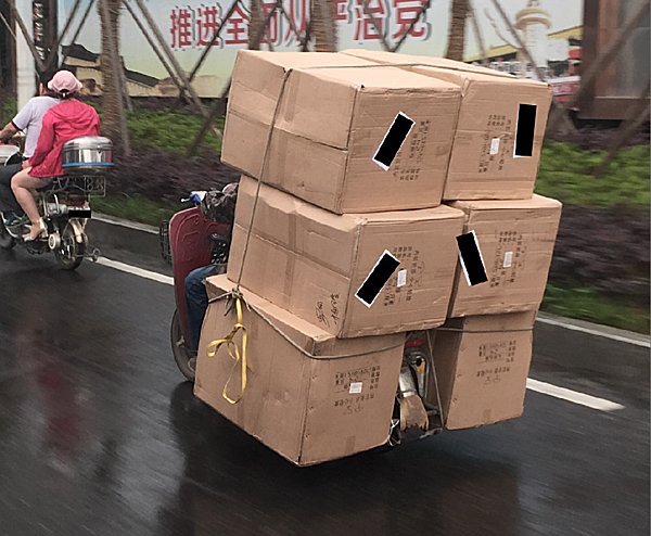 ハンドル部分が浮いたような状態で、信じられない量の荷物を原付きバイクで運ぶ人も（中国にて）