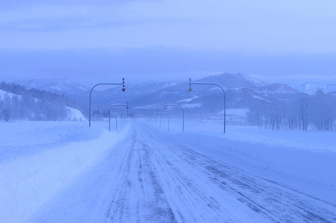 矢羽根が指し示すにところに沿って除雪されている。吹雪の時は矢羽根が運転の道しるべ